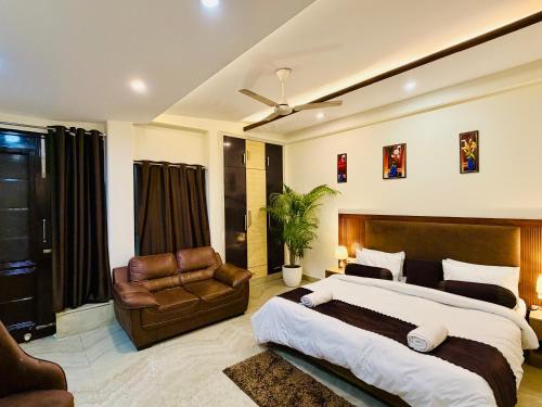 a bedroom with a large bed and a leather chair at Hotel Prime Stay in Noida