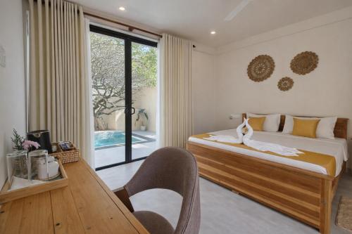 a bedroom with a bed and a table with a chair at Gatch Villa in Unawatuna