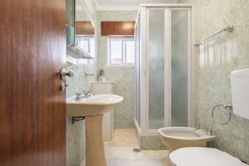 ein Badezimmer mit Toilette, Waschbecken und Dusche in der Unterkunft Stay in Corroios Near Lisbon and 15 Min from the Beach - Casa Acolhedora em Corroios Perto de Lisboa e da Praia in Corroios
