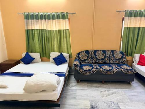 a room with two beds and a chair and curtains at Ozzy Rooms in Kolkata