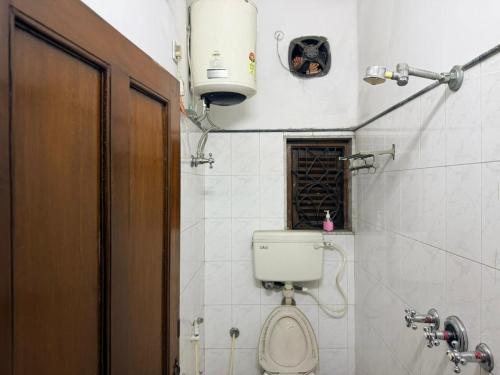 a small bathroom with a toilet and a window at Ozzy Rooms in Kolkata