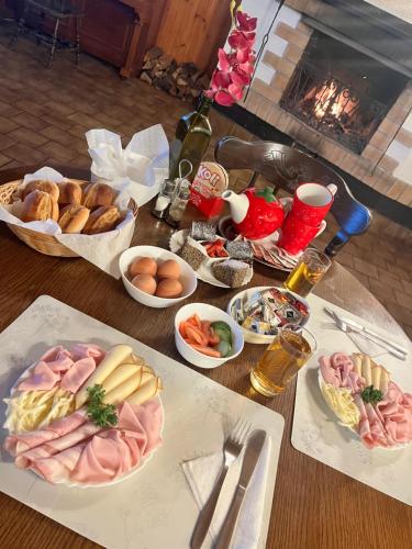 a table topped with plates of food and a bottle of wine at Hotel & Restaurant Adolfovský Dvůr in Adolfov
