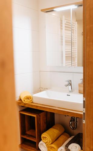 a bathroom with a sink and a mirror and towels at Ferienhof Leopold in der Grub in Ort