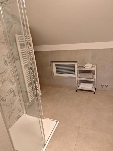 a bathroom with a walk in shower and a window at Apartma 198 in Kranjska Gora