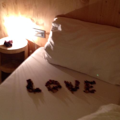 a bed with some flowers on it with a pillow at Apartments Resi in Rasùn di Sotto