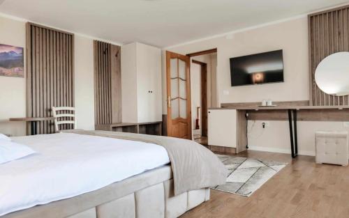 a bedroom with a bed and a desk and a television at Pensiunea Maria in Agapia