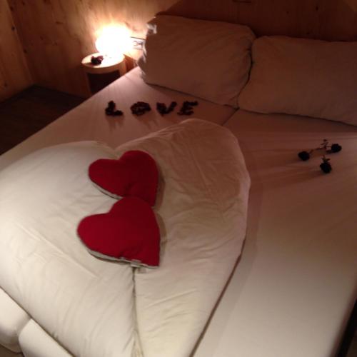 two hearts on a bed with the words love at Apartments Resi in Rasùn di Sotto