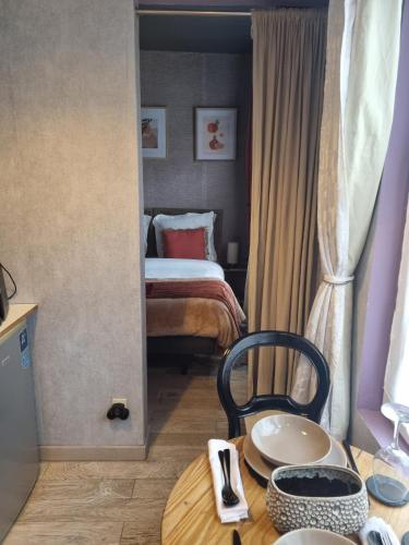 a bedroom with a bed and a table with a chair at Villa Seven Petit Studio coin kitchenette in Dunkerque