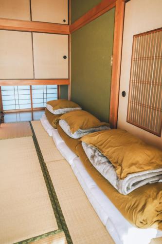 a row of cots in a room at keganiya 一棟貸し北九州空港近くの和風宿 in Yukuhashi