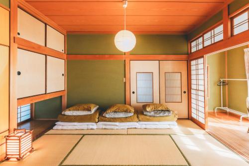a japanese room with a couch and windows at keganiya 一棟貸し北九州空港近くの和風宿 in Yukuhashi