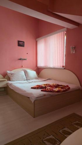 a bedroom with a large bed with pink walls at Guest House Blisten in Sofia