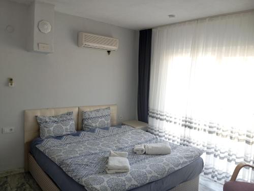 a bedroom with a large bed with towels on it at Gelinkızı Apart in Kargınküre