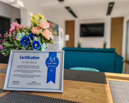 a sign on a table with a bouquet of flowers at NOVA House Apartments in Delniţa