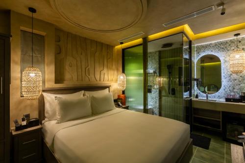 ein Schlafzimmer mit Bett und ein Badezimmer mit Dusche in der Unterkunft Pynt Hotel 8 in Ho-Chi-Minh-Stadt
