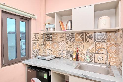 a kitchen with a sink and a tile wall at Trên Mây HST - 181 Trần Phú in Hanoi