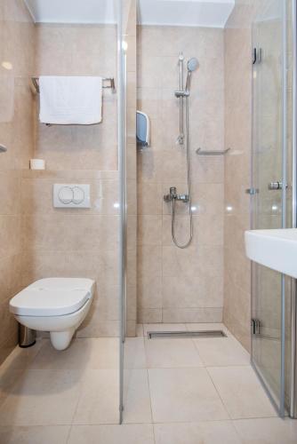 a bathroom with a shower and a toilet and a sink at Hotel Vlaho in Skopje