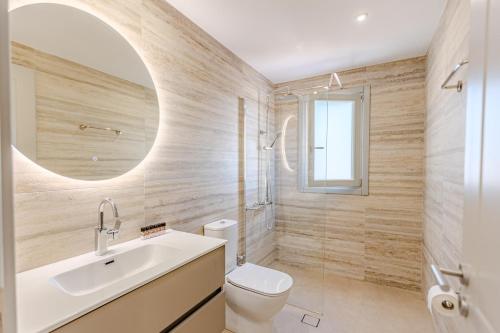 a bathroom with a sink and a toilet and a mirror at Lipsi Grand Villas in Leipsoi