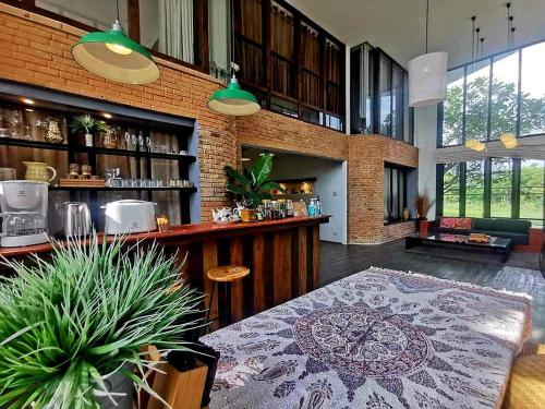 a bar with a table and a counter in a room at Baantidnam in Ban Thung Tho