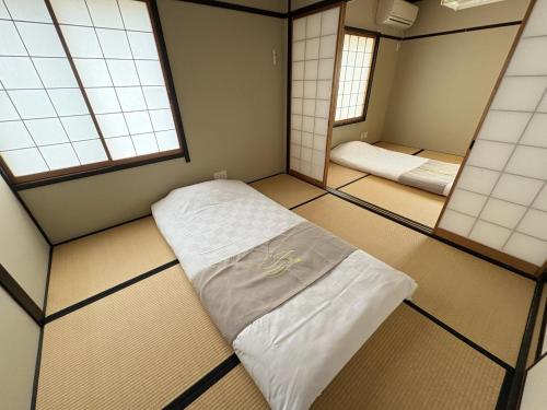 a small room with a bed and two mirrors at 夏様楽善 Historic Kyoto Machiya,Experience Japanese Lifestyle Comfortably in Kyoto