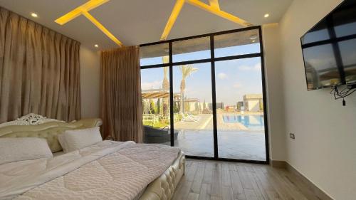 a bedroom with a bed and a large sliding glass door at Villa W2 in Amman
