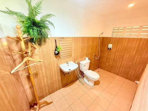 a bathroom with a toilet and a palm tree in it at Kohmook sunrise beach in Ko Muk