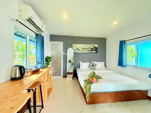 a bedroom with a bed and a desk and windows at Kohmook sunrise beach in Ko Muk