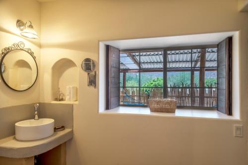 La salle de bains est pourvue d'un lavabo et d'une fenêtre. dans l'établissement Terra del Valle Bed & Breakfast, à Valle de Guadalupe