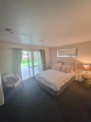a bedroom with a large white bed and a window at Private Ensuite Room in Rolleston