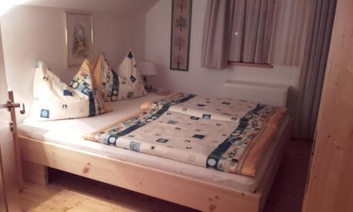 ein Bett mit einem Holzrahmen in einem Schlafzimmer in der Unterkunft Die Buche in Hermagor