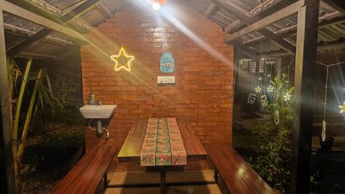 a bathroom with a sink and a brick wall at Gangadharam Tiny House 2BHK AC in Tellicherry
