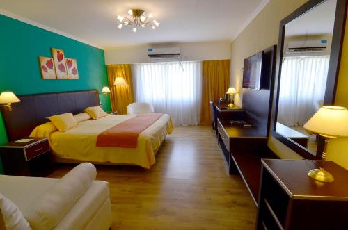 a hotel room with two beds and a flat screen tv at Alto Verde Suite & Apart in Termas de Río Hondo