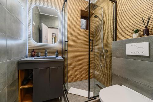 a bathroom with a sink and a shower with a mirror at Old Town Urban Nest in Braşov