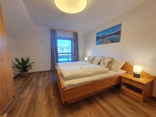 a bedroom with a bed and a large window at Ferienhof Leopold in der Grub in Ort
