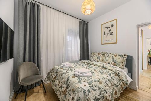 a bedroom with a bed and a chair and a window at Old Town Urban Nest in Braşov