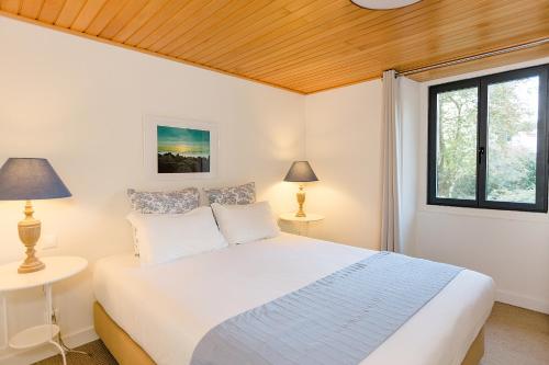 a bedroom with a white bed and two lamps at Sintra Bliss A Part in Sintra