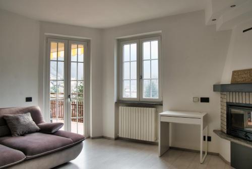 a living room with a couch and a fireplace at Terrazza in centro Valsassina in Introbio
