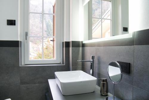 a bathroom with a white sink and a mirror at Terrazza in centro Valsassina in Introbio