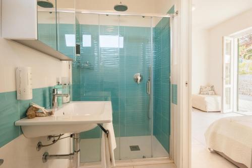 a bathroom with a sink and a glass shower at Cala Azzurra in Marciana