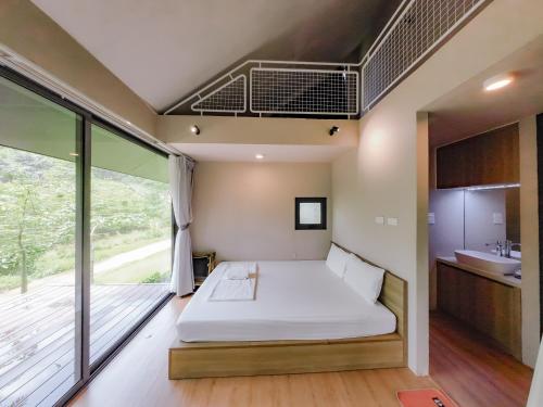 a bedroom with a bed and a balcony at Thung May Resort - Venuestay in Ba Vì