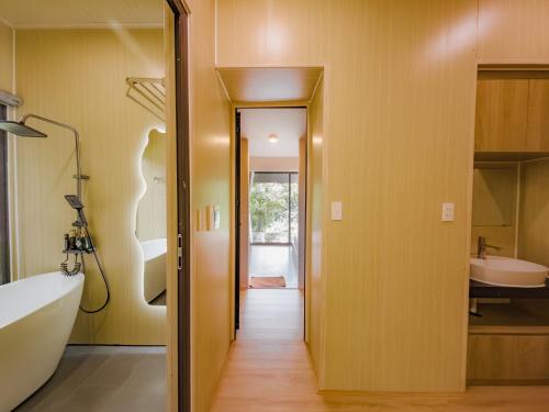 a bathroom with a tub and a sink at Thung May Resort - Venuestay in Ba Vì