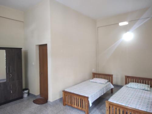 a room with two beds and a tv in it at Bridgettine Paradise in Sultan Bathery