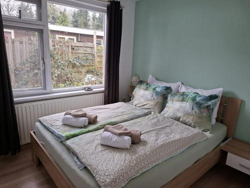 a bedroom with a bed with towels on it at Vakantiehuis met privetuin op rustig bospark Veluwe in Voorthuizen