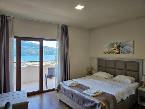 ein Schlafzimmer mit einem großen Bett und einem Balkon in der Unterkunft Hotel Olimpija plus in Herceg-Novi