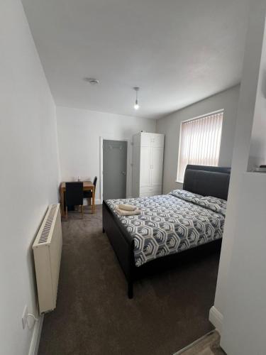 a bedroom with a bed and a desk and a chair at Comfy private studio Moseley in Birmingham