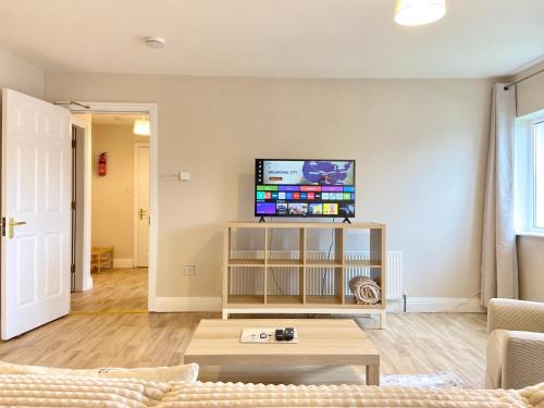 a living room with a couch and a tv on a wall at Anchors Rest, Cobh in Cobh