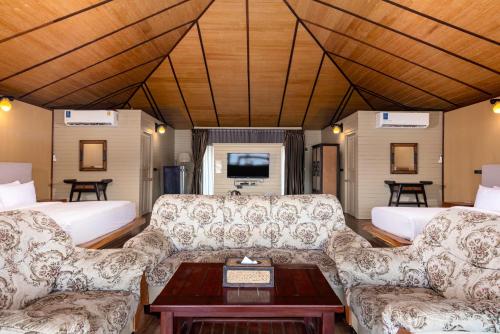 a living room with two couches and a table at Ruknam Resort in Ban Hin Hak