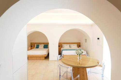 a room with two beds and a table and chairs at Resort San Giacomo con Piscina in San Michele Salentino