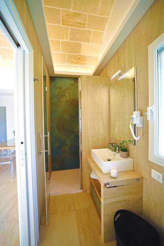 a bathroom with a sink and a mirror at Resort San Giacomo con Piscina in San Michele Salentino