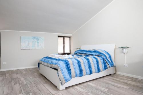 a bedroom with a bed with a blue and white comforter at Al Lago da Lilly in Gargnano