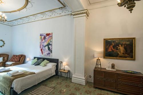 1 dormitorio con 1 cama y una pintura en la pared en Cal Comabella, en Balaguer
